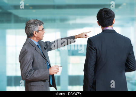 Businessman giving direction to his colleague Stock Photo