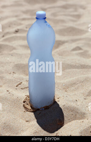 Santa Margherita di Pula, Italy, with frozen water bottle is in the sand