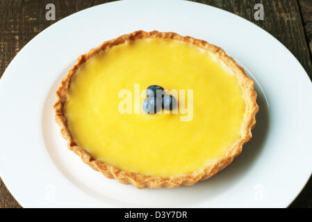 Fresh Meyer Lemon tart with golden pastry crust and blueberries Stock Photo