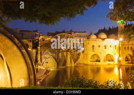 Norias and Nur al-Din mosque by the Orontes river in Hama, Syria Stock Photo