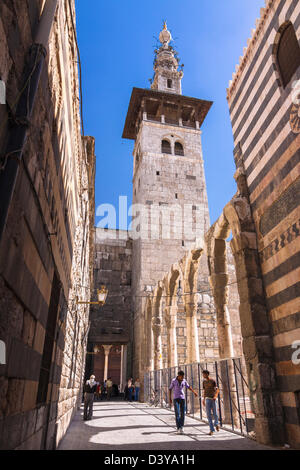 Minaret of the Bride, the oldest of the Umayyad Mosque as seen from an alley in the old town. Damascus, Syria Stock Photo