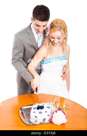 Happy bride and groom together cutting wedding cake, isolated on white background. Stock Photo