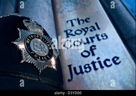 Metropolitan Police helmet and badge in London outside with entrance sign to Royal Courts of Justice Holborn London UK Stock Photo