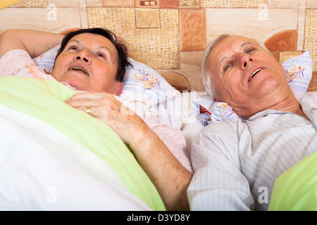 Close up of happy senior couple resting in bed at home. Stock Photo
