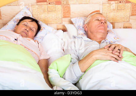 Close up of senior man and woman sleeping in bed. Stock Photo