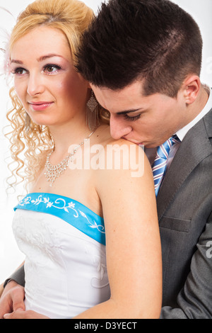 Close up of wedding couple hugging and kissing on shoulder. Stock Photo