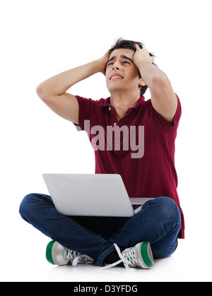 Man suffering from a headache and looking at a laptop Stock Photo