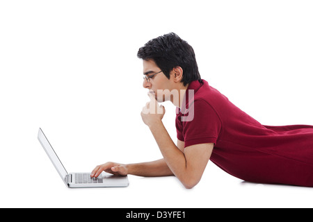 Man lying on the floor and using a laptop Stock Photo