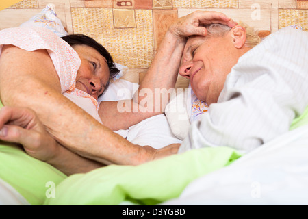 Close up of happy loving senior couple relaxing in bed. Stock Photo