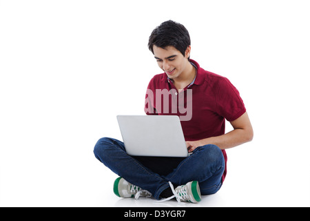 Man sitting on the floor and using a laptop Stock Photo