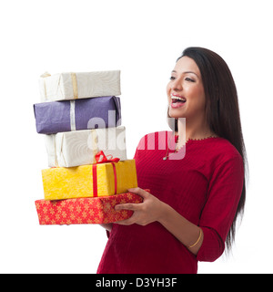 Happy woman holding stack of gifts and smiling Stock Photo