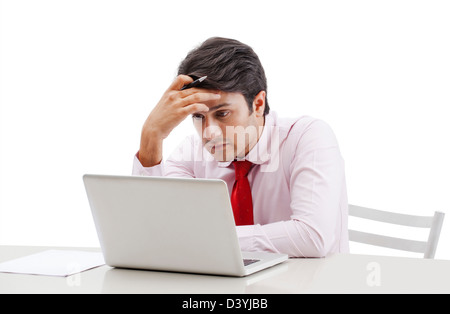 Businessman looking sad while working on a laptop Stock Photo