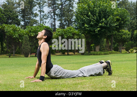 Man doing snake pose in a park Stock Photo