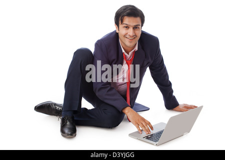 Businessman working on a laptop and smiling Stock Photo