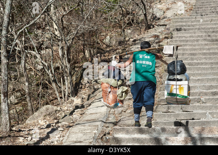 A porter carries supplies towards the summit of Huangshan, Anhui Province, China Stock Photo