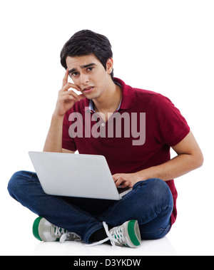 Portrait of a man using a laptop and thinking Stock Photo