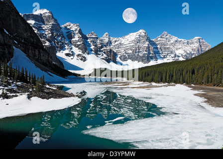 full moon over Wenkchemna Peaks reflected in Moraine Lake in spring Stock Photo