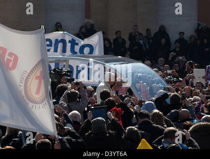 Rome, Italy. 27th February 2013 Pope Benedict XVI kisses a child from the crowd handed to him by his secretary. Credit: Nelson Pereira/Alamy Live News Stock Photo