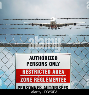 Jumbo Jet and Restricted Area Sign on Chain Link Fence with Barbed Wire, Pearson International Airport, Toronto, Ontario, Canada Stock Photo