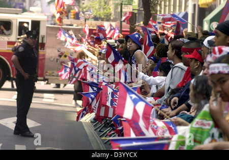 Spectators wave flags and cheer at the 45th Annual Puerto Rican Day Parade on June 9, 2002 in New York. Stock Photo