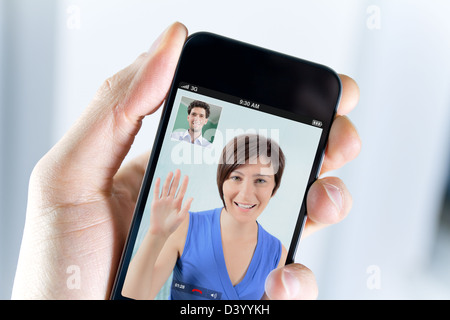 Closeup of a male hand holding a smartphone during a video call with his girl field Stock Photo