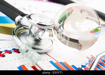 Stethoscop and globe on a statistics graphic Stock Photo