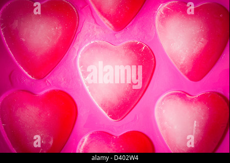 Heart-Shaped Ice Cubes in a Pink Ice Cube Tray Stock Photo