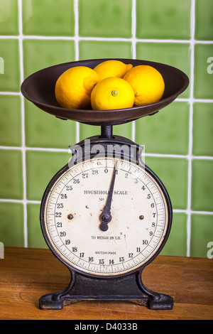 Old mechanical kitchen scales with lemons in the pan Stock Photo