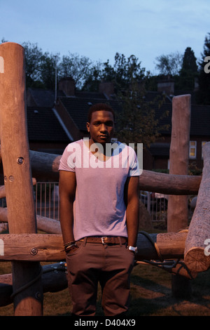 Black man standing in a play area at night. Stock Photo