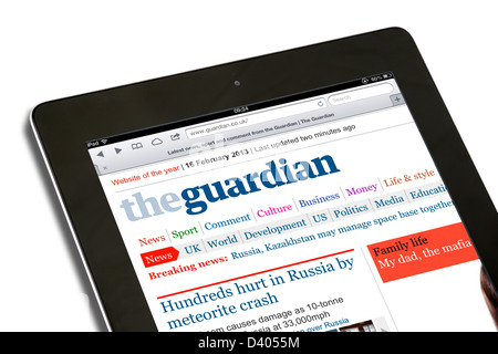 Reading the internet edition of the Guardian online newspaper on a 4th Generation iPad, UK Stock Photo