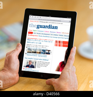 Reading the internet edition of the Guardian online newspaper on a 4th Generation iPad, UK Stock Photo