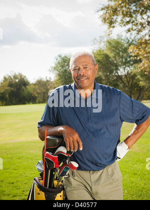 Black man carrying golf clubs Stock Photo