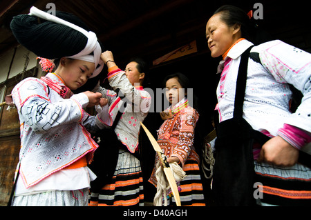 A Long Horn Miao teenage girl getting ready for the Tiao Hua festival in Guizhou. Stock Photo