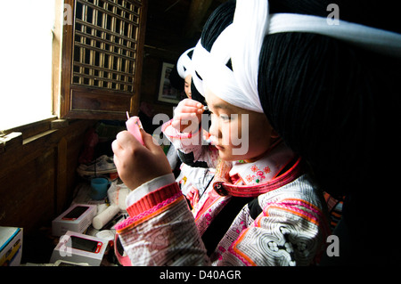 Long Horn Miao teenage girls getting ready for the Tiao Hua festival in Guizhou. Stock Photo