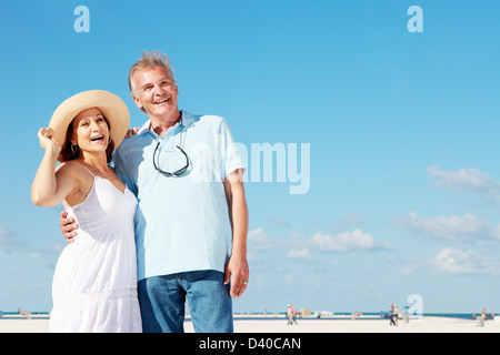 A retiree couple enjoying a summer vacation by the beach Stock Photo