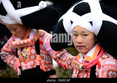 A Long Horn Miao little girl in traditional costumes dancing to celebrate the Tiao Hua festival / spring festival in Guizhou. Stock Photo