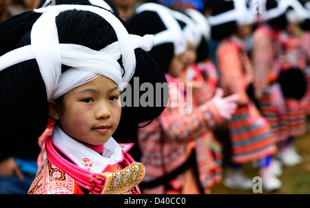 A Long Horn Miao little girl in traditional costumes dancing to celebrate the Tiao Hua festival / spring festival in Guizhou. Stock Photo