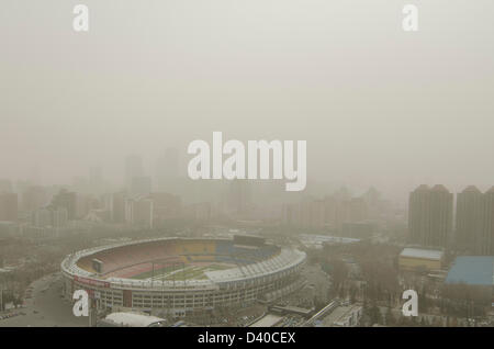 Aerial view across the Worker Stadium, also known as Gongti, with the skyline of the Chinese capital city shrouded in smog. Whenever the northerly winds stop, the polluting coal power stations, crop burning and traffic fumes combine, resulting in hazardous air pollution with levels often in excess of 500 on the Air Quality Index, as seen here in the Chaoyang district of Bejiing, China, PRC. © Time-Snaps Stock Photo