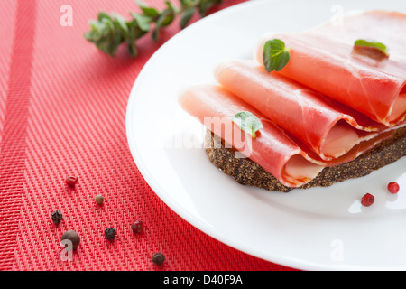 thin ham on a piece of black bread, closeup Stock Photo