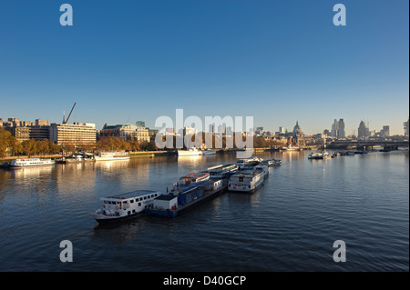 River Thames looking East from Waterloo Bridge at sunrise with boats in the foreground Stock Photo