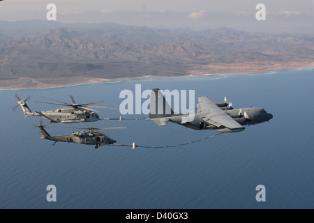 A hercules  MC-130 refuels a  CH-53 Super Stallionand  HH-60 Pave Hawk helicopter Stock Photo