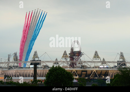 Royal Air Force Red Arrows trailing red, white and blue smoke as they pass over the Opening Ceremony for the London 2012 Olympics, UK Stock Photo