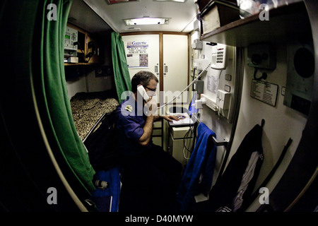 Crew man on phone in bunk room of Nuclear Submarine HMS Talent Stock Photo