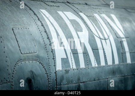 Close-up side view of military airplane with big white army inscription. Old war aircraft in metal plates. Military aviation. Re Stock Photo