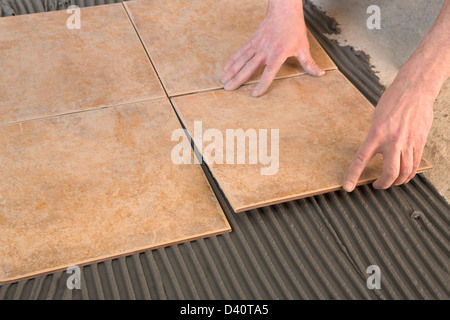 gluing tiles laid on the adhesive Stock Photo
