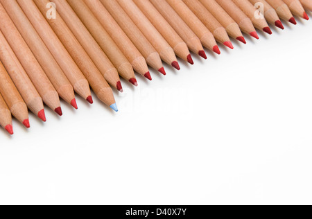 Line of red colouring pencils with one blue pencil sticking out - difference concept Stock Photo