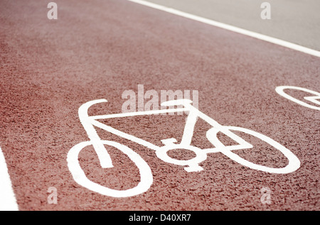 Designated cycle lane path symbol painted on a red asphalt road surface, UK Stock Photo