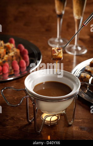 piece of cake dipped into a chocolate fondue Stock Photo