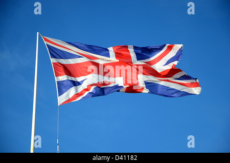 British Union Jack flag fluttering on flagpole Stock Photo