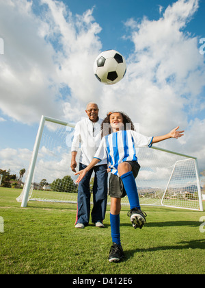 Man playing soccer with granddaughter Stock Photo
